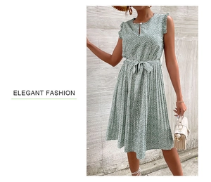 Detail view of the green floral sleeveless dress showing the pleated skirt and waist tie