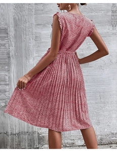 Detail of red floral pleated dress featuring sleeveless ruffled cuffs and high waistline