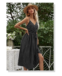 Detailed close-up of side slit and waist tie on black polka dot midi dress