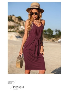 Dettaglio dell'abito bordeaux senza maniche con scollo a V e cintura annodata sulla spiaggia