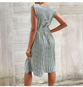 Detail view of the green floral summer dress featuring ruffled shoulders and pleated hemline