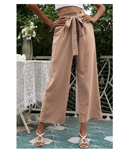Détail d'un pantalon large taille haute beige avec taille élastique et ceinture à nœud