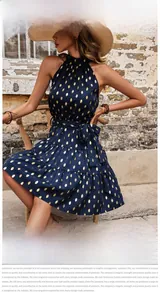 Detailed close-up of dark blue halter dress with golden metallic polka dots and tiered skirt