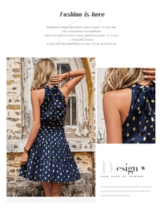 Detail of navy sleeveless halter neck dress with gold polka dots and a large bow tie