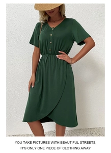 Detail of V-neck button closure and elastic waist on dark green summer wrap dress