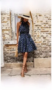 Detail of navy sleeveless halter neck dress with gold polka dots and layered cake hemline