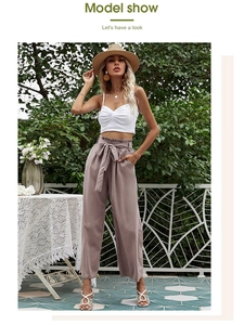 Détail du pantalon taille haute à jambes larges rose poudré avec ceinture à nœud assortie