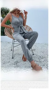 Detail of grey sleeveless jumpsuit featuring a V-neckline and adjustable waist bow tie