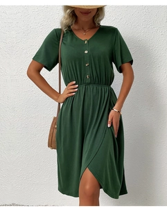 Detail view of dark green V-neck midi dress with buttoned waist and irregular slit hemline