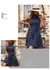 Detailed view of dark blue halter neck dress with gold polka dots and layered cake hem