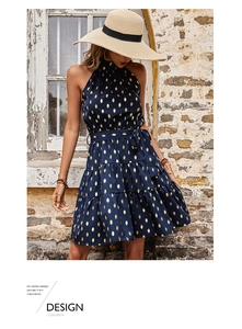 Detail of navy sleeveless halter dress with gold foil polka dots and layered skirt hem