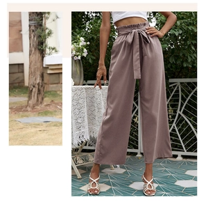 Détail d'un pantalon large à taille haute froncée avec une ceinture nouée assortie