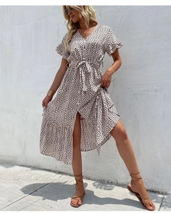 Detail of floral V-neck dress with ruffle sleeves, waist tie, and elegant side slit