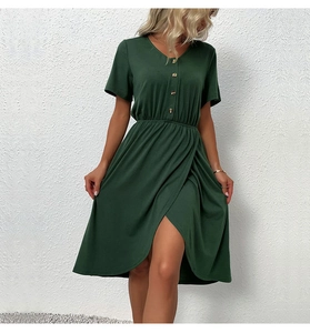 Detail view of the V-neckline with brown buttons on a dark green wrap dress