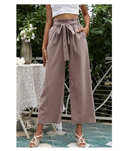 Détail de la taille haute paperbag avec ceinture assortie sur le pantalon large rose poudré