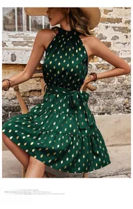 Detail of green halter neck dress with gold polka dots and a waist tie ribbon