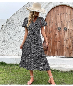 Detail of V-neck floral midi dress featuring a waist tie and ruffled hem in black and white