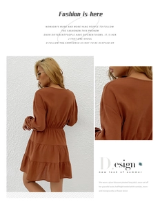 Detail view of the rust brown long sleeve dress featuring tiered hem and cinched waist