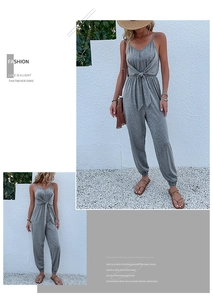 Detail view of the gray sleeveless jumpsuit with V-neckline and waist knot tie design