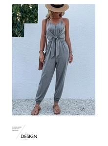 Detail of grey V-neck summer jumpsuit with knotted waist and cinched leg cuffs