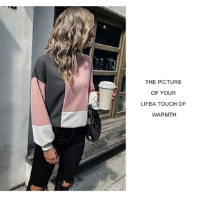 Detail of color-block knit sweater with pink and grey panels and white ribbed cuffs