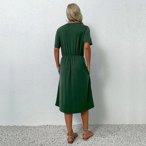 Back view of a dark green short sleeve dress with elastic waist and asymmetrical hemline