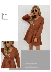 Detail showing the deep V-neckline, button accents, and drawstring waist of this brown dress