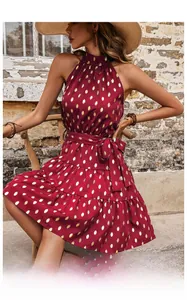 Detail of red tiered dress with gold foil polka dots and bohemian waist tie