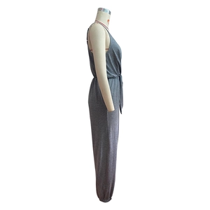 Side view of grey knit sleeveless jumpsuit featuring waist tie and ribbed ankle cuffs
