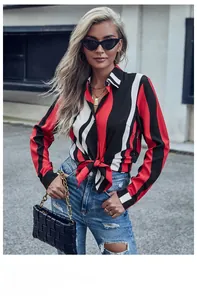 Détail d'une chemise à rayures rouges et noires avec poignets boutonnés et motif vertical