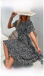 Abito estivo bianco e nero a fiori con cintura e cappello di paglia all'aria aperta