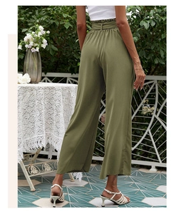 Détail du pantalon large vert olive à taille haute avec ceinture assortie et plis élégants