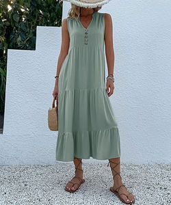 Detail of light green tiered summer maxi dress with V-neckline and button accents