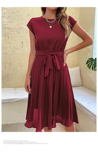 Detail of burgundy pleated dress featuring elegant waist tie and cap sleeve design