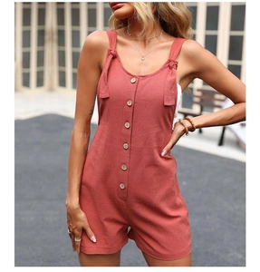 Détail d'un combishort en lin de coton rouge rouille avec boutons et bretelles nouées