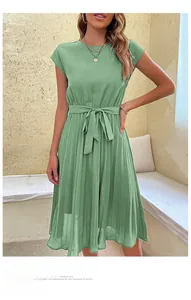 Detailed view of sage green pleated dress with elegant round neck and belted waist