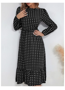 Détail de la robe mi-longue vintage à pois noirs avec ourlet à volants et taille ajustée
