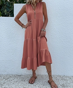 Detail view of the V-neckline and wooden buttons on this coral orange tiered maxi dress