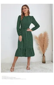 Détail d'une robe vert foncé à pois avec taille froncée et ourlet à volants de style sirène