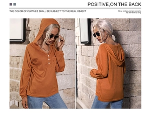 Detailaufnahme des orangefarbenen Kapuzenpullovers mit Waffelstruktur und Knopfleiste