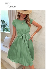 Detail of green pleated dress featuring a high waist tie-belt and elegant round neckline