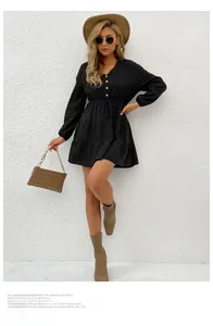 Detail of black long sleeve dress featuring drawstring waist and tiered ruffle skirt