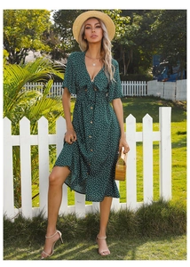 Detailed view of dark green polka dot midi dress with V-neck bow and wooden buttons