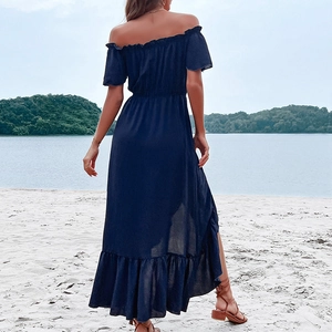 Navy blue off-shoulder maxi dress with ruffle sleeves and irregular hem on a beach