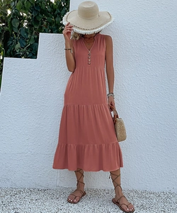Detail of coral pink tiered maxi dress with V-neckline and decorative button row