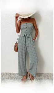 Detail of green floral strapless wide leg jumpsuit with front buttons and waist tie design
