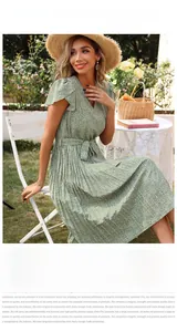 Détail de la robe plissée à fleurs vertes avec col en V, lien à la taille et manches volantées