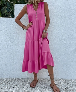 Detail of rose pink V-neck maxi dress featuring wooden buttons and tiered skirt