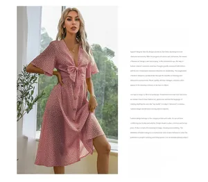 Detail of pink polka dot V-neck dress with bow waist and elegant ruffled sleeves