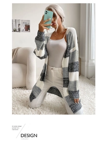 Close-up of long-sleeved striped knit cardigan with grey and white patchwork patterns